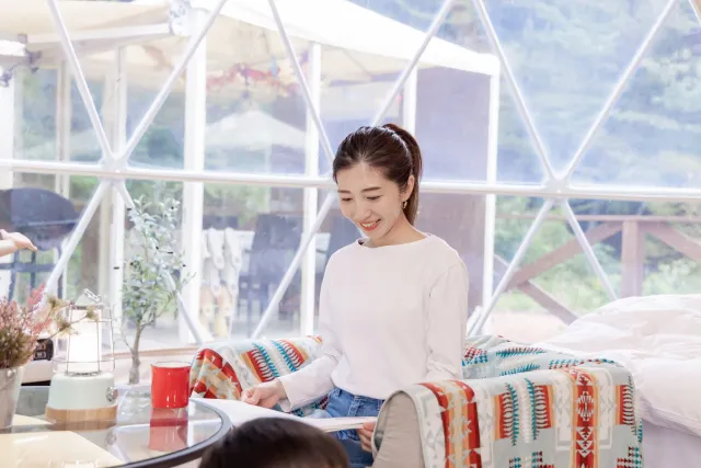 グランピングのテントの中でくつろぐ女性の画像